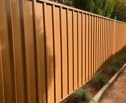 A newly installed orange Colorbond fence in Port Macquarie